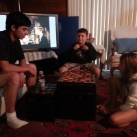 Leilani learning chess with her uncle while brother "pops" his collar!